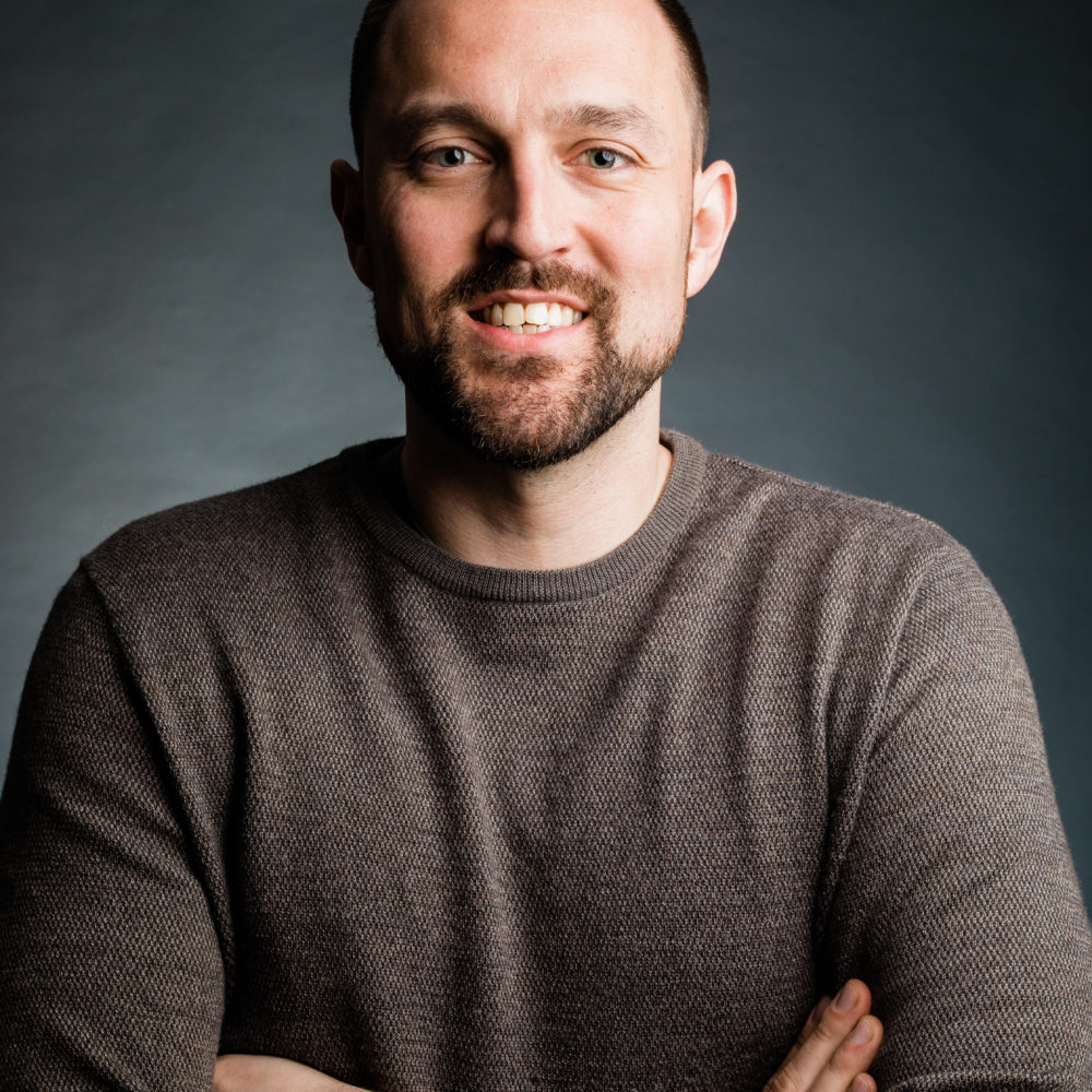 smiling man with beard and his arms crossed over his chest